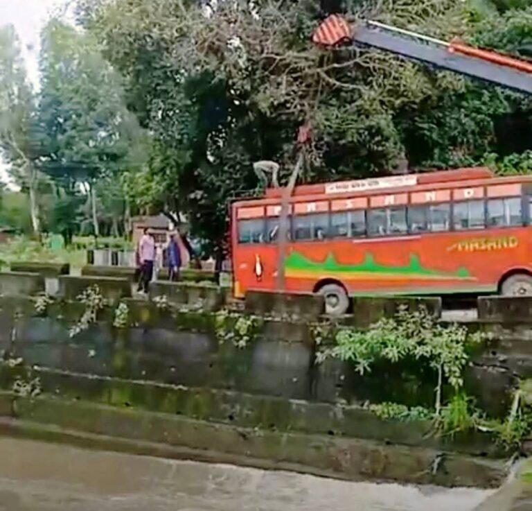 Kangra: समलोटी में बड़ा हादसा टला! धंसी सड़क पर फंसी निजी बस, JCB से बचाई गई